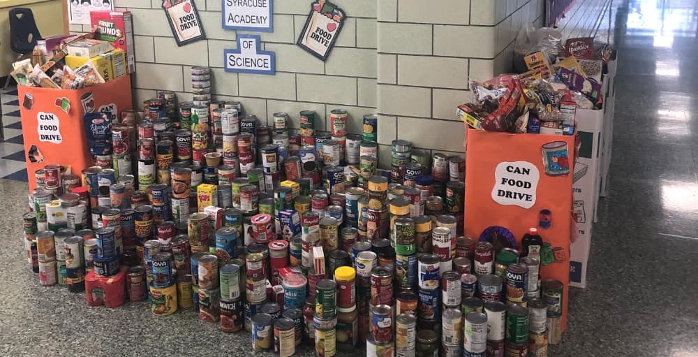 Syracuse Academy of Science elementary school put love into action by donating hundreds of canned goods this Thanksgiving season to benefit the Rescue Mission.